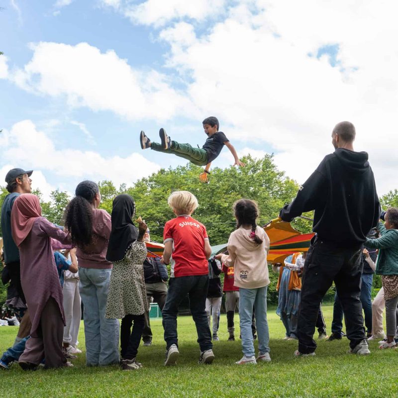 Kinder spielen am Jubliäumsfest der SFW mit Springtuch.