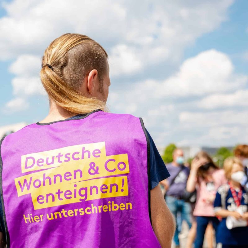 Aktivist für Initiative «Deutsche Wohnen & Co. enteignen» mit violetter Weste.